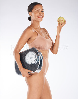 Buy stock photo Portrait, black woman and body with apple, scale and diet for weight loss, health and wellness on grey studio background. Face, African American female and happy lady with fruit, fitness or nutrition