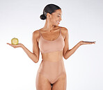 Black woman, fitness and body with an apple, chocolate and smile for balance, wellness and grey studio background. Mockup, African American female and lady with fruit, candy bar and diet on backdrop