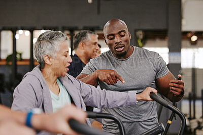 Buy stock photo Elderly group, exercise bike and personal trainer for fitness, timer and retirement wellness by blurred background. Senior woman, bicycle training and diversity with black man, progress and coaching