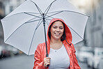 Umbrella, happy and portrait of a woman in the city walking in the rain while on a vacation. Travel, happiness and female with a red jacket on an outdoor walk in town on holiday in black and white.