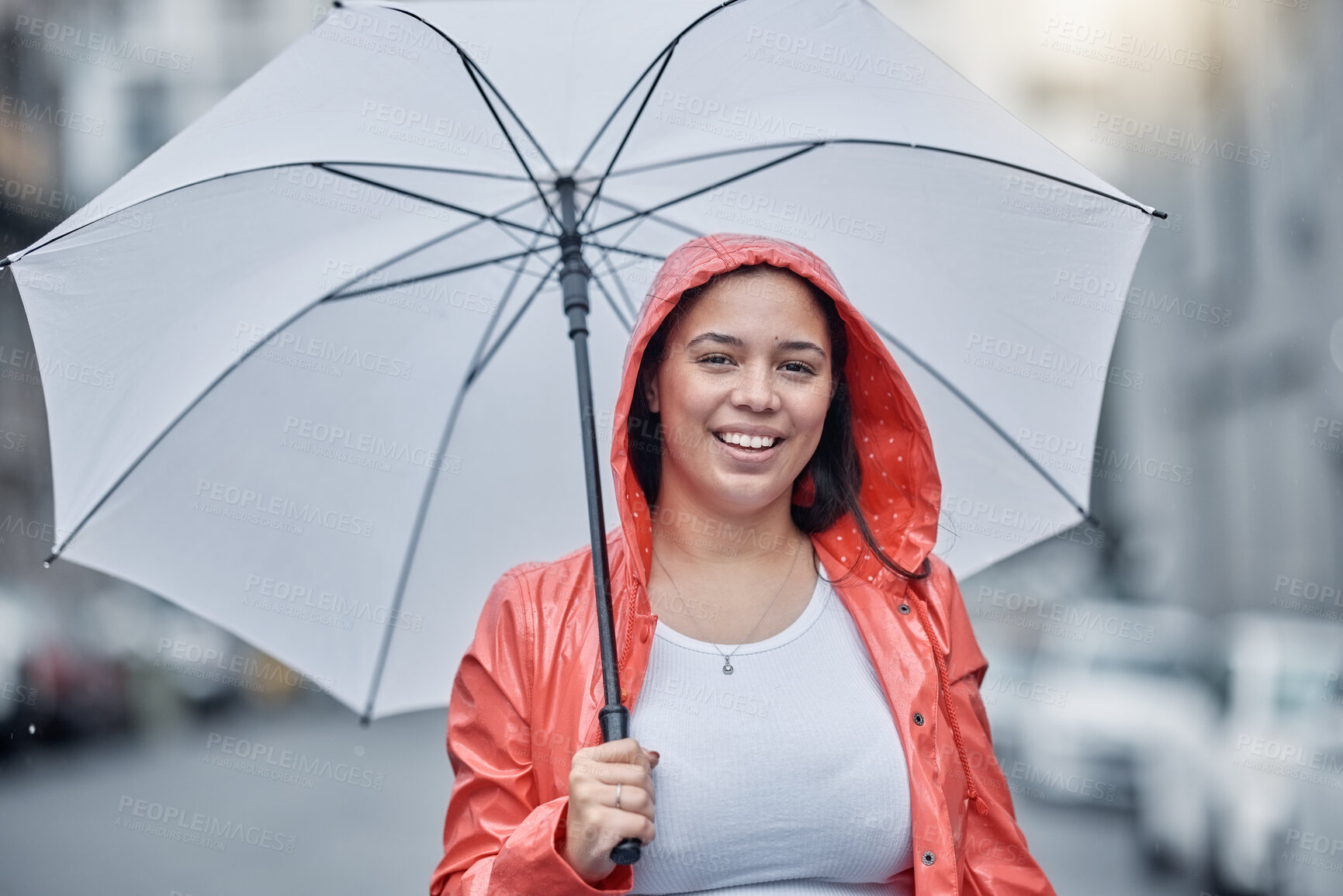 Buy stock photo Umbrella, happy and portrait of a woman in the city walking in the rain while on a vacation. Travel, happiness and female with a red jacket on an outdoor walk in town on holiday in black and white.