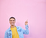 Happy, pointing and portrait of a man in a studio with mockup space for advertising, marketing or product placement. Happiness, smile and male model showing mock up or copyspace by a pink background.