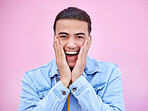 Man, hands and cheeks for surprise in portrait with happiness, excited and pink wall background. Happy gen z model, wow face and smile for announcement, fashion and news for career, success and goal