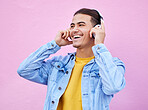 Headphones, man and smile on pink background, wall backdrop or studio mockup. Excited guy listening to music, sound and streaming audio media with freedom, happy face and hearing radio for podcast 