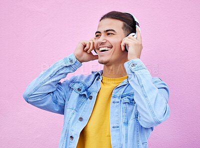 Headphones, man and smile on pink background, wall backdrop or studio mockup. Excited guy listening to music, sound and streaming audio media with freedom, happy face and hearing radio for podcast
