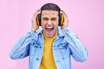 Buy stock photo Headphones, man and screaming portrait on background, pink wall backdrop or studio mockup. Crazy guy listening to music, shouting and loud volume for streaming media with sound, audio hearing or face