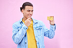 Credit card, thinking and man holding banking product with doubt of shopping, payment and ecommerce. Decision, pay choice and savings questions of a model isolated with pink background in studio