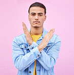 No, stop and portrait of a man with hands as a sign isolated on a pink studio background. Angry, caution and serious person with a rejection, decline and problem gesture with arms on a backdrop