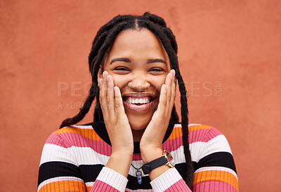 Buy stock photo Excited black woman, hands and cheeks in portrait by city wall background with smile, happiness and beauty. Gen z student girl, young model and fashion in urban metro for adventure, happy and freedom