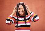 Wall, portrait and black woman with headphones, smile and carefree with music, streaming and joyful. Face, Jamaican and female with headset for audio, sounds and chilling with happiness and relax