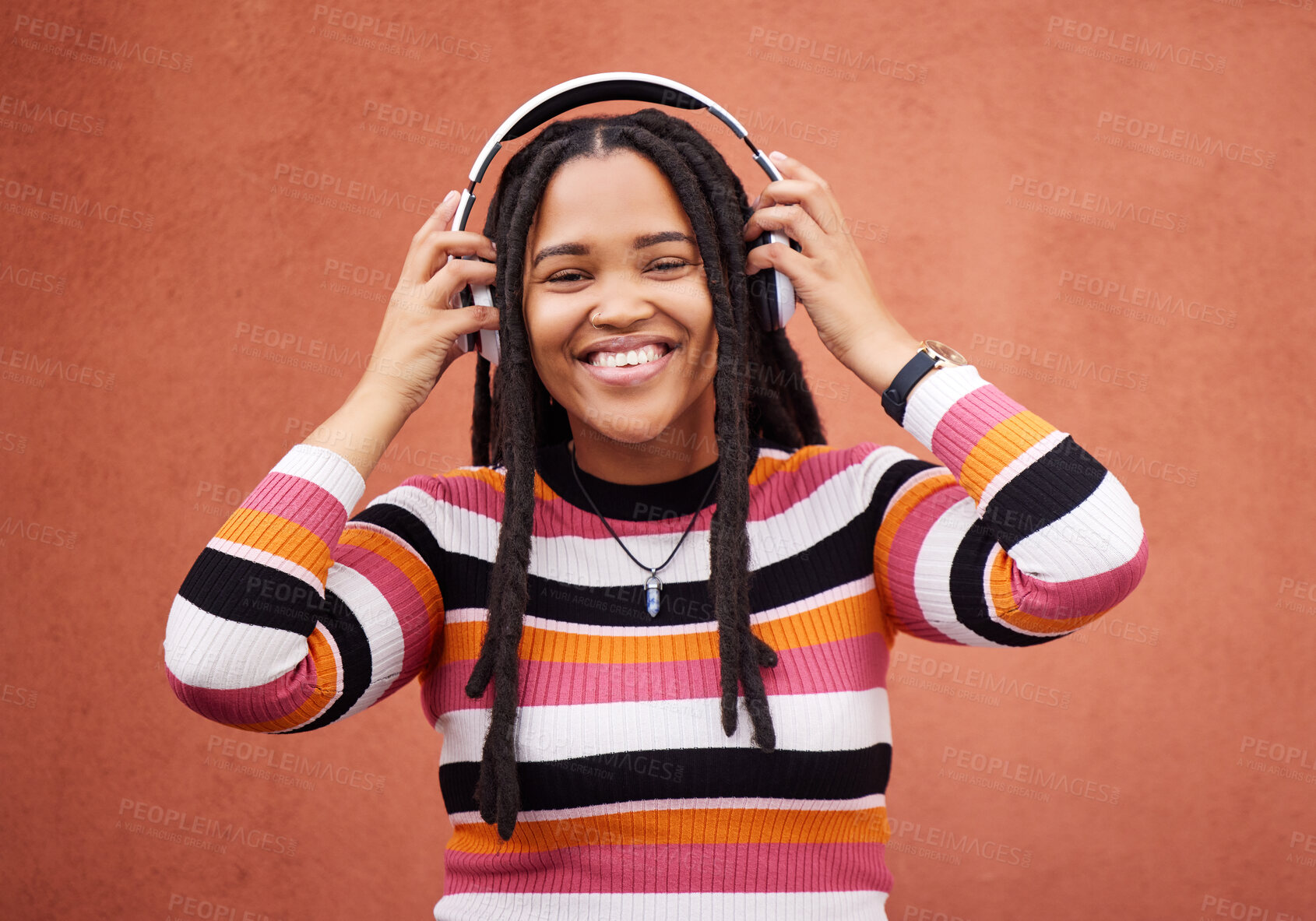 Buy stock photo Wall, portrait and black woman with headphones, smile and carefree with music, streaming and joyful. Face, Jamaican and female with headset for audio, sounds and chilling with happiness and relax