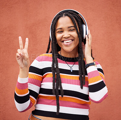 Buy stock photo Portrait, headphones and black woman with peace sign isolated on orange wall for gen z music or mental health. Young person or v hands of youth listening to audio 5g technology or streaming services