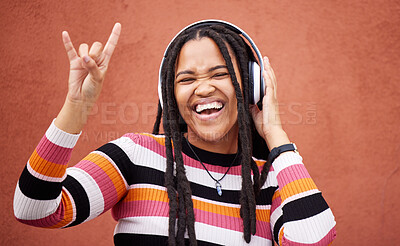 Buy stock photo Rock sign, headphones and black woman isolated on orange wall for gen z music subscription or mental health. Young person or excited youth listening to audio 5g technology or streaming services