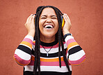 Black woman, music headphones and smile by wall in city for walk, adventure or happy laughing for comedy. Young gen z girl, audio streaming or comic podcast on website, internet or happiness in metro