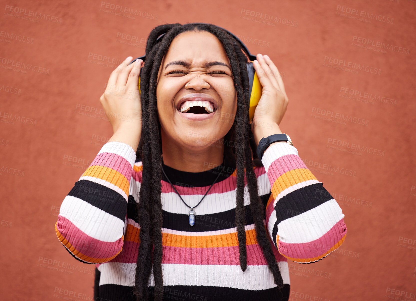 Buy stock photo Black woman, music headphones and smile by wall in city for walk, adventure or happy laughing for comedy. Young gen z girl, audio streaming or comic podcast on website, internet or happiness in metro