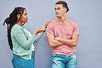 Young interracial couple, wall background and argument in city with black woman, question and conversation. Gen z man, partner and conflict in metro with relationship, fight and  angry arms crossed