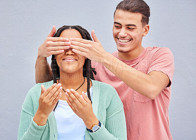 Buy stock photo Wow, surprise or hands and a couple on a gray background outdoor with a man covering the eyes of his girlfriend. Diversity, hands or dating with a woman being surprised by her boyfriend on a wall