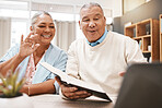 Wave, laptop and senior couple on video call with book or bible for spiritual studying or reading in home. Greeting, retirement and elderly man and woman waving on online or web chat with computer.