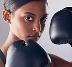 Boxing, gloves and portrait face of woman in studio for exercise, strong focus or mma training. Female boxer, workout and fist fight for impact, energy and warrior power in battle, fitness and action