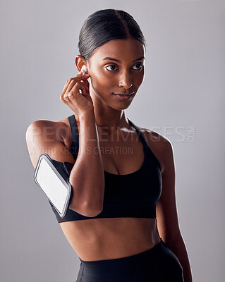 Buy stock photo Fitness, music and woman in studio for exercise, wellness and advertising on grey background space. Workout, mockup and girl relax with podcast, audio for track for motivation while training isolated