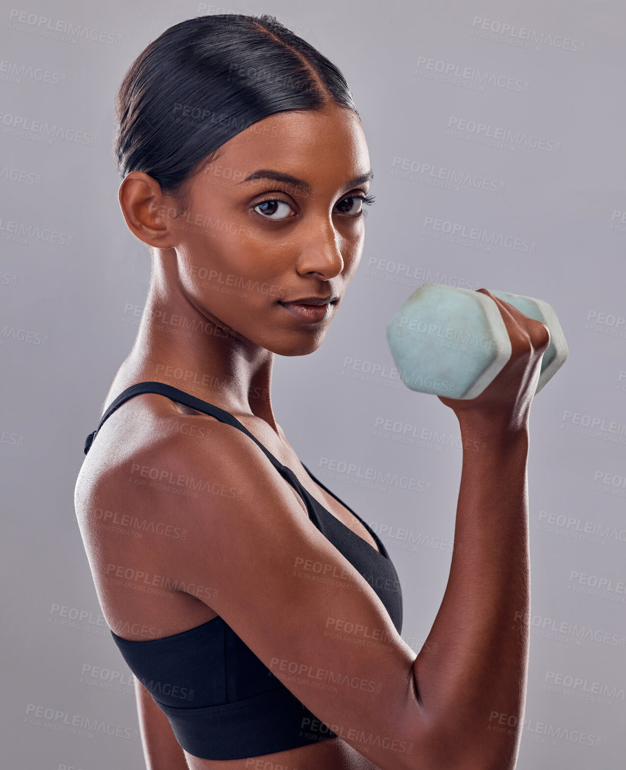 Buy stock photo Woman, portrait and bicep with dumbbell in studio for strong body, action and focus exercise. Indian female, bodybuilder and weights of fitness, power training and muscle energy for sports workout 