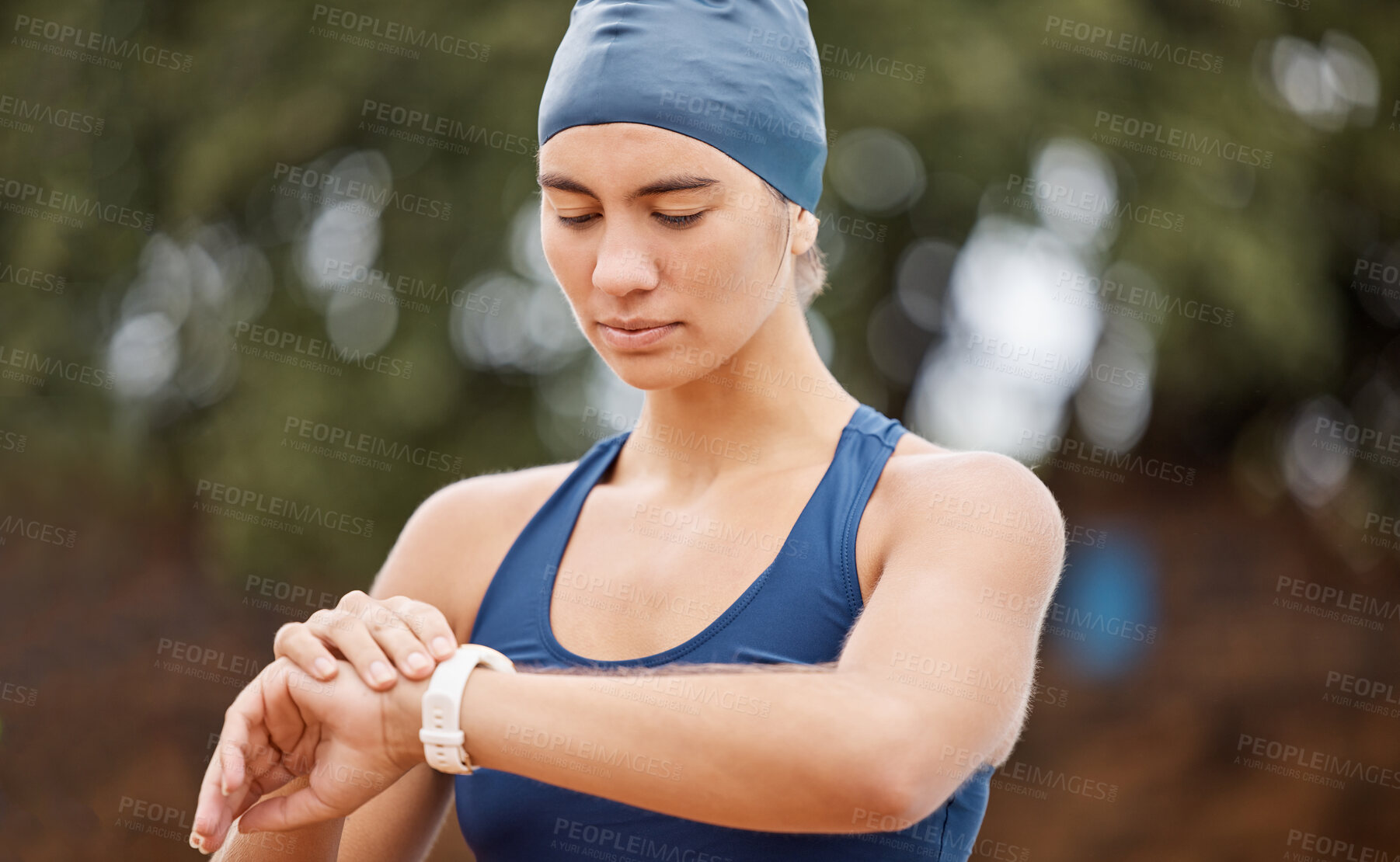 Buy stock photo Woman swimmer, looking and smartwatch for training, time or wellness for development, exercise or contest. Girl, swimming workout and check watch for health, heart rate or focus by blurred background