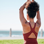 Yoga, zen and back view of black woman at beach on yoga mat
