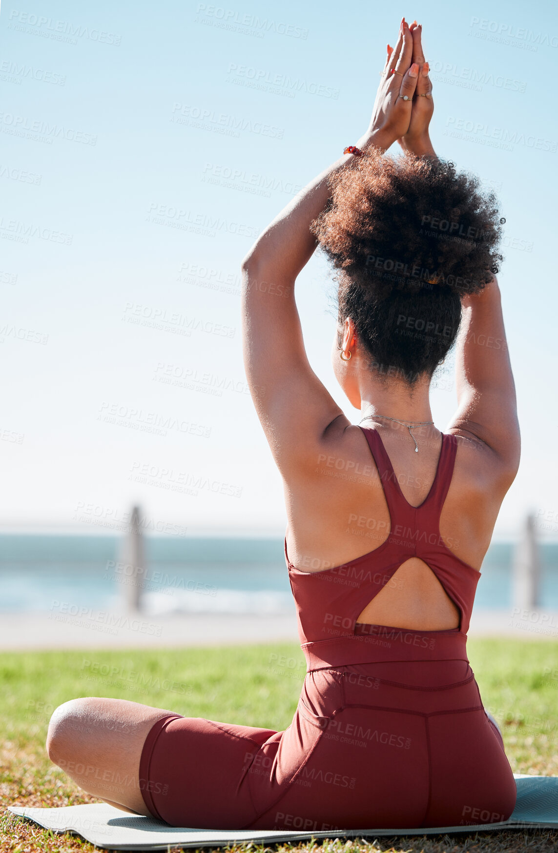 Buy stock photo Fitness, black woman and meditation on yoga mat by beach for spiritual wellness or exercise in nature. Sporty female yogi back in warm up arm stretch for zen workout, relax or awareness in meditating