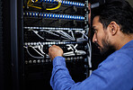 Engineer, server room and man with cable connection for software update or maintenance at night. Information technology wire, cloud computing and male programmer check database network in data center