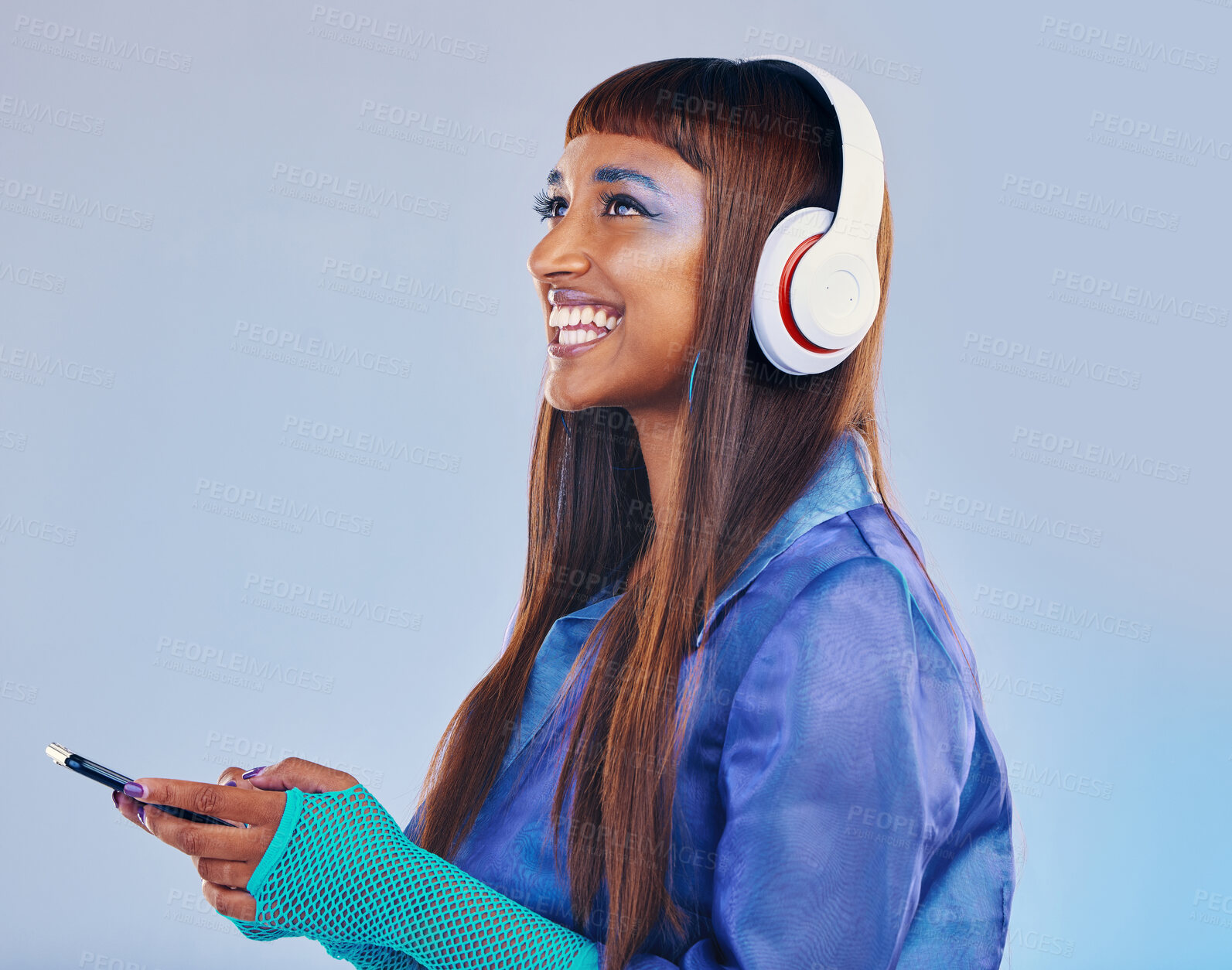 Buy stock photo Headphones, black woman and phone isolated on blue background for cyberpunk fashion and gen z thinking. Young person or beauty model with idea or listening to music on smartphone technology in studio