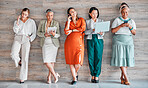 Wall, business and women with devices, online reading and connection for social media, typing and communication. Diversity, female employees and happy coworkers chatting, texting and search internet