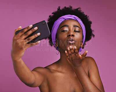 Buy stock photo Selfie, love and black woman blowing a kiss isolated on a purple background in studio. Care, beauty and African girl with a photo, video call or communication on a mobile while showing affection