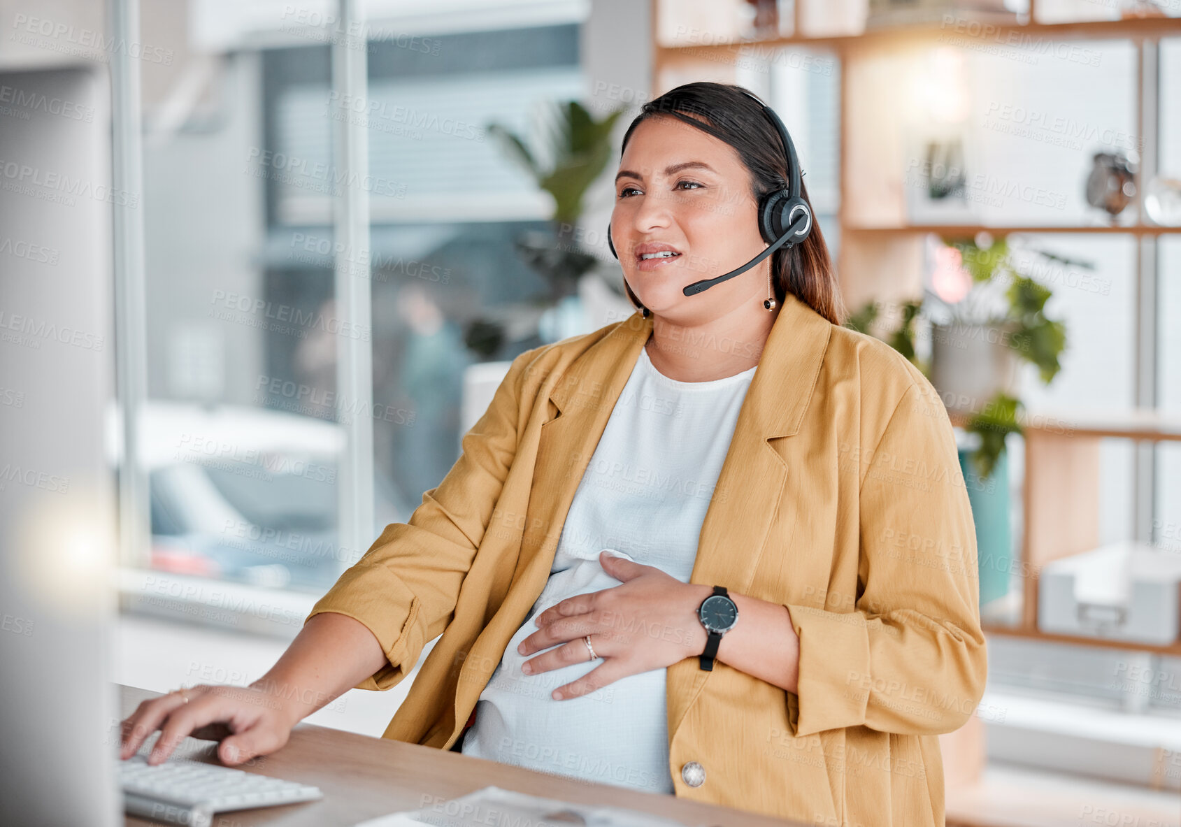 Buy stock photo Office, stress and pregnancy, woman at desk with hand on stomach, exhausted in call center with headset. Burnout, pain and pregnant telemarketing consultant with anxiety from deadline time pressure.