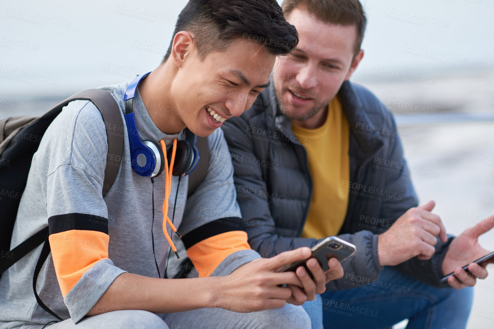 Buy stock photo Asian man, phone and friends by the sea happy about mobile connection and travel. Technology, social media scroll and ocean with men streaming a video with 5g network outdoor with happiness together