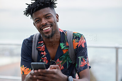 Buy stock photo Black man, travel and portrait with smartphone and outdoor with communication, adventure at beach and backpacking. Holiday, happy and chat, check social media or post with 5g, technology and vacation