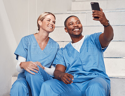 Buy stock photo Healthcare, doctors and selfie in hospital, smile and fun together, bonding or achievement. Medical professionals, woman or black man with smartphone, picture for memories or in clinic with happiness