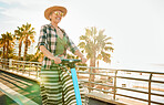 Electric scooter, happy and senior woman on a vacation, weekend trip or adventure on beach promenade. Happiness, freedom and elderly lady in retirement having fun while on summer holiday in Australia
