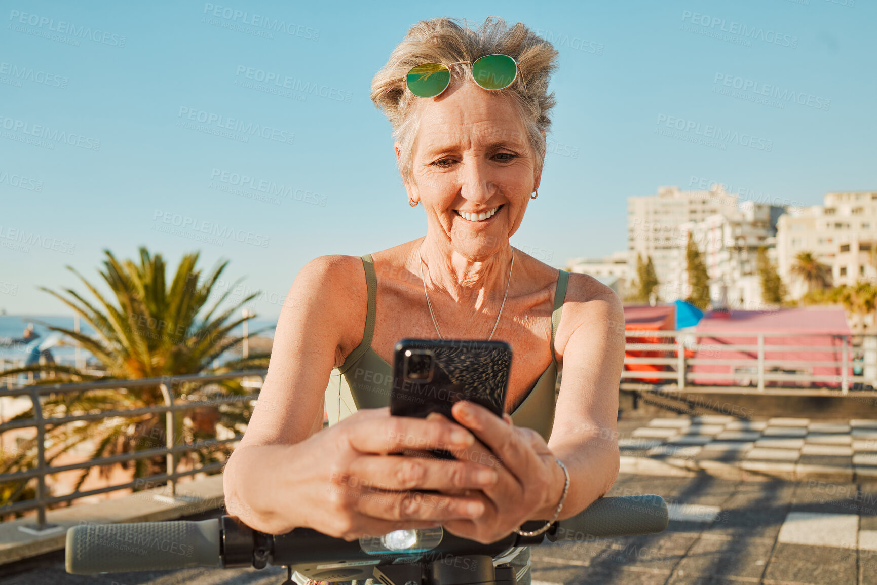 Buy stock photo Holiday, promenade or senior woman with smartphone, connection or scooter on weekend trip. Mature female, old lady or cellphone for typing, social media or share adventure, journey or tropical island