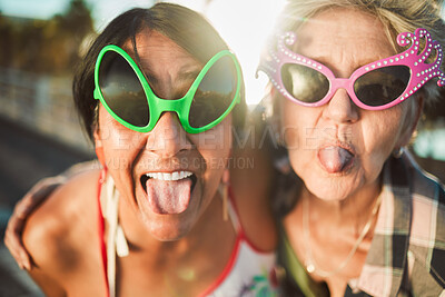 Buy stock photo Funny, selfie and tongue out by senior women with sunglasses outdoors for travel, break and bonding on blurred background. Emoji, face and crazy elderly friends pose for photo, profile picture or fun