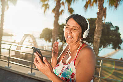 Buy stock photo Summer, music and senior woman at beach with headphones on weekend, holiday and Miami vacation. Travel, retirement and happy elderly female listening to song, radio and audio for calm, fun and relax