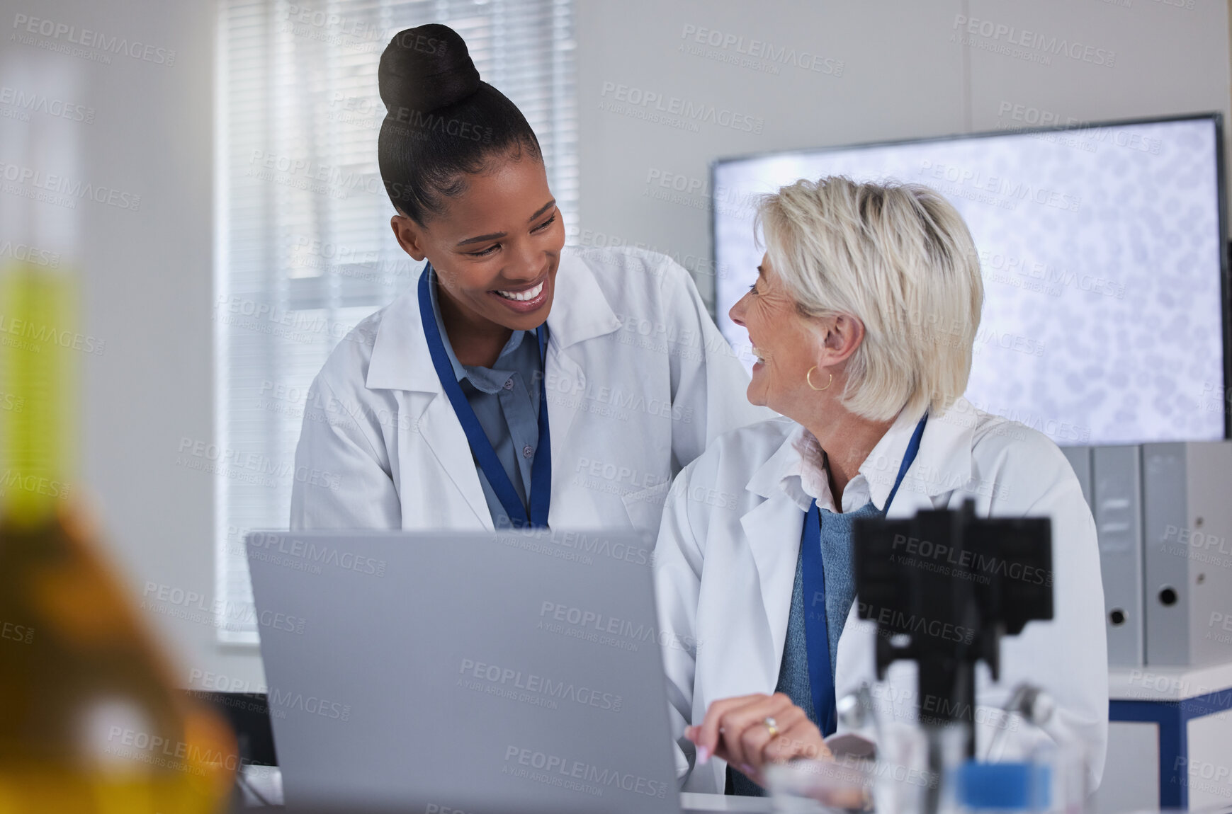 Buy stock photo Teamwork, laptop and collaboration of doctors in laboratory for medical research or science. Computer, comic and researchers, black woman and senior female, talking and laughing at funny comedy meme.