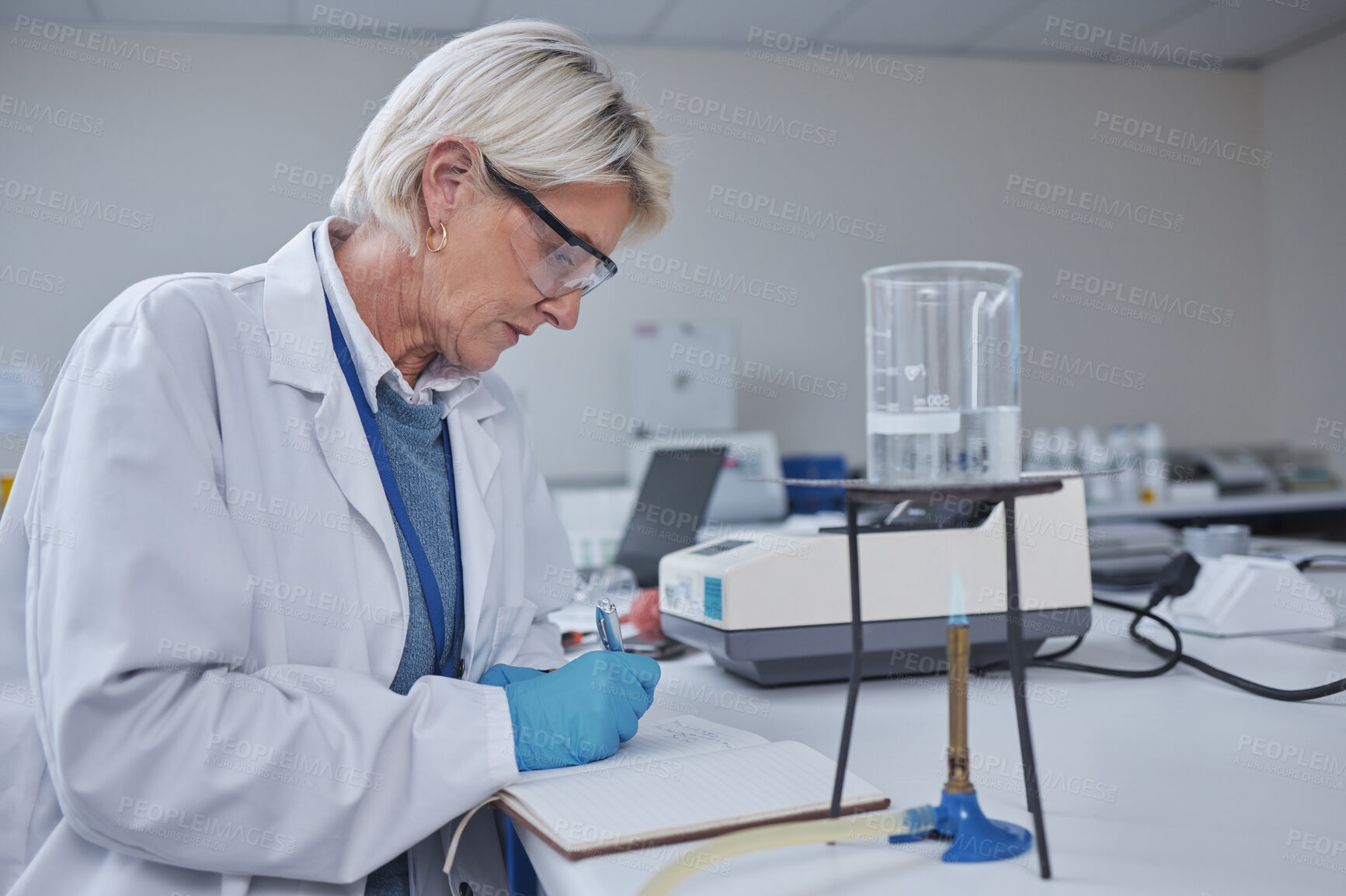 Buy stock photo Science, research and woman writing notes or data in notebook with burner experiment on desk. Healthcare, innovation and female scientist working on vaccine manufacturing and future medical analytics