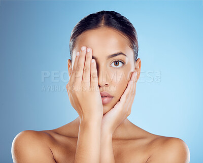 Buy stock photo Portrait, hands and woman cover face for beauty, studio and skincare cosmetics on blue background. Female model, facial and dermatology transformation of healthy aesthetic, laser and natural shine