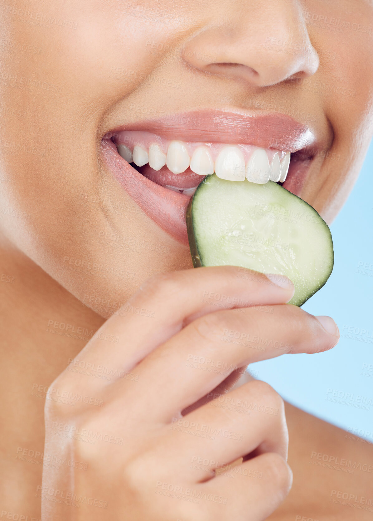 Buy stock photo Closeup, mouth and cucumber by woman in studio for wellness, detox or skincare on blue background. Fruit, snack and girl model with snack during beauty, facial and happy with organic product isolated