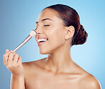 Makeup brush, beauty smile and woman with cosmetics, skincare and wellness tool. Blue background, studio and model with cosmetic application tools for dermatology, self love and happy skin glow