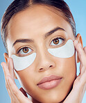 Face, skincare and woman with eye patches in studio isolated on a blue background. Dermatology, portrait and female model with facial cosmetics or pad product for healthy skin, wellness and beauty.