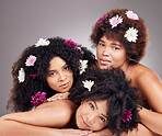 Hair care, friends and portrait of black women with flowers in studio isolated on gray background. Floral cosmetics, organic makeup and face of group of girls with flower for beauty and aesthetic.