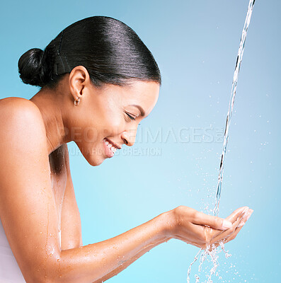 Buy stock photo Hands, water splash and black woman isolated on blue background for face skincare, cosmetics or hands cleaning. Person or beauty model smile in facial wash, dermatology hygiene or aesthetic in studio