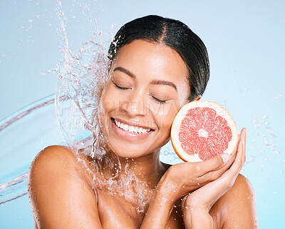 Buy stock photo Skin care, beauty and woman with a grapefruit for healthy skin and diet on a blue background. Face of aesthetic model person with water splash and fruit for sustainable facial health and wellness