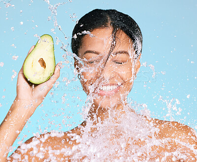 Buy stock photo Beauty, water splash and woman with avocado for healthy skin and diet on a blue background. Face of aesthetic model person with skin care and green food for sustainable facial health and wellness